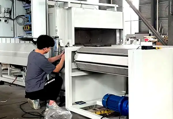 ZonHoo field engineer commissioning a conveyor industrial oven during on-site installation
