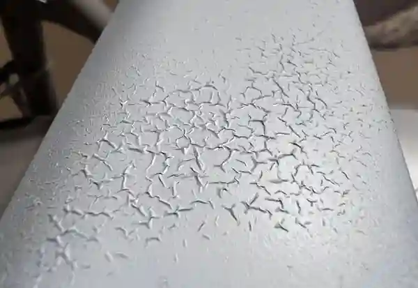 Coating surface cracking defect caused by improper industrial oven curing, a common issue addressed in our FAQ