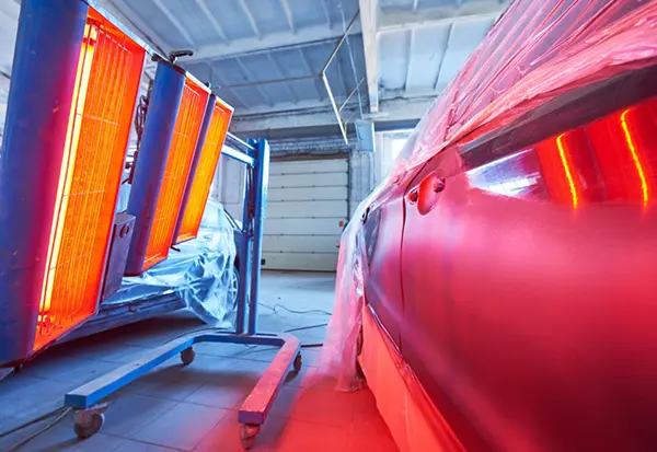 Automotive body panels cured with infrared heaters in a paint shop, illustrating ZonHoo industrial oven applications for car manufacturing