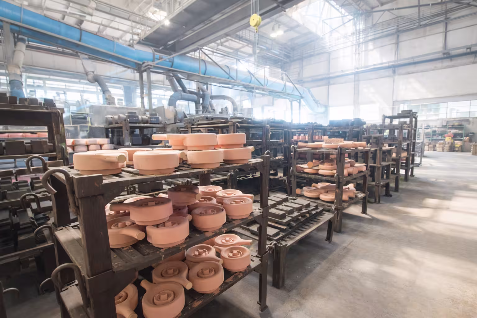 Sand cores and molds on fixtures for continuous drying in a foundry